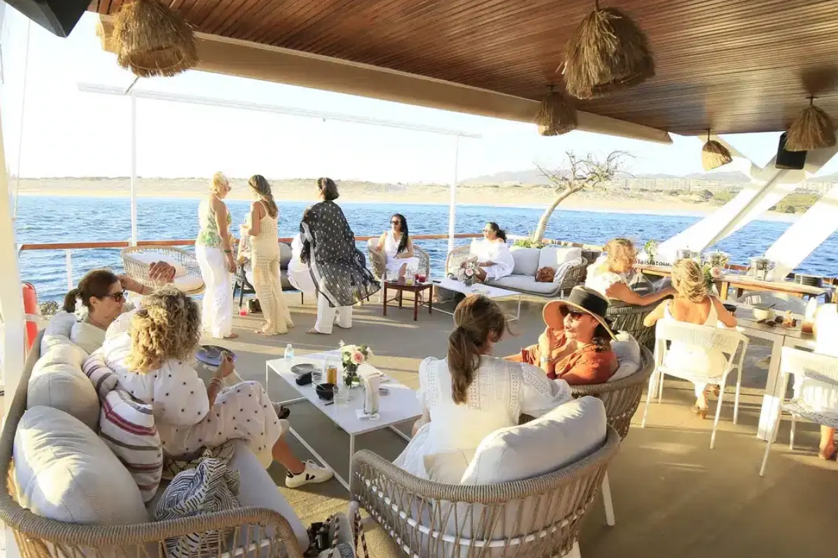 Guests enjoying drinks in the shaded lounge deck of a charter catamaran