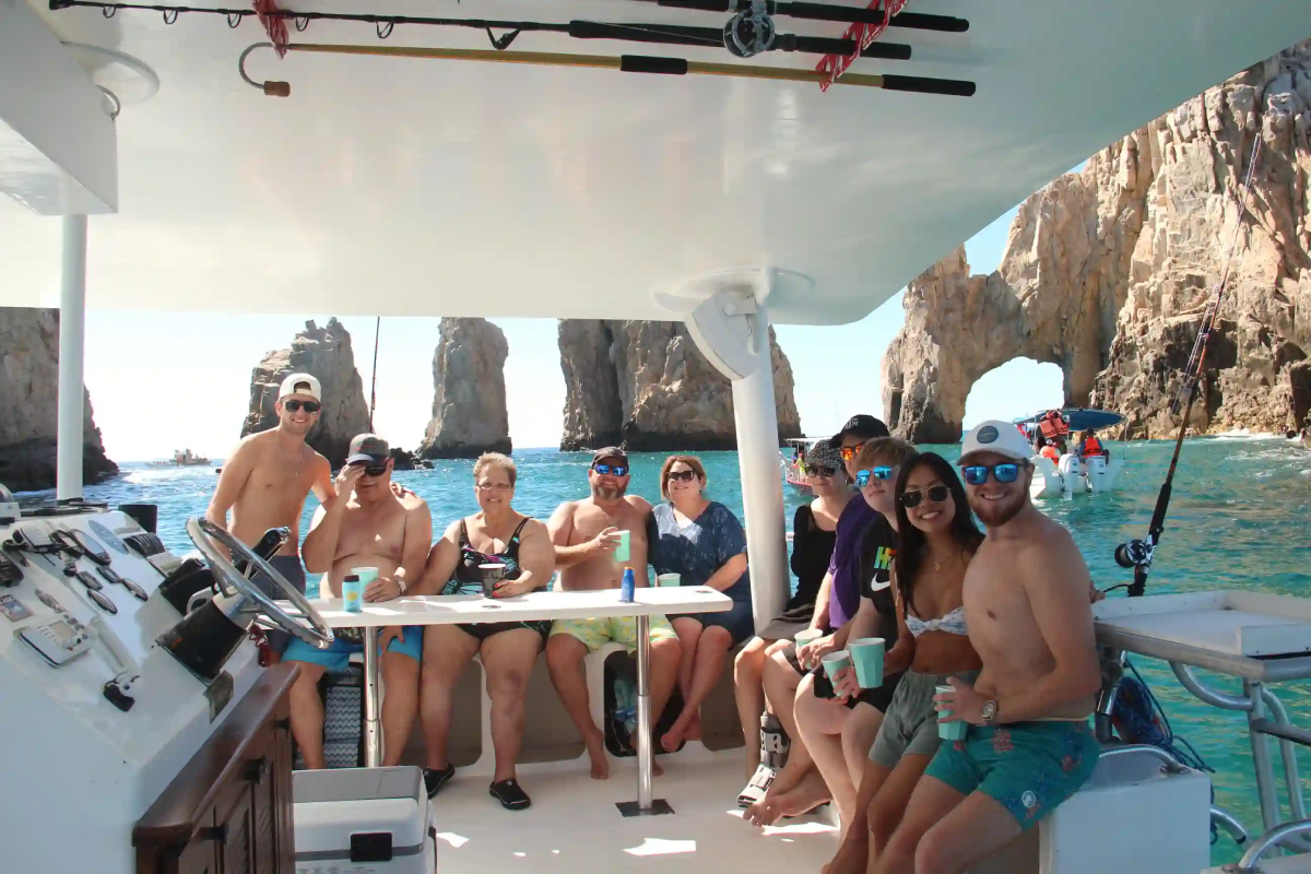 Guests enjoying drinks aboard a private catamaran charter near the Arch in Cabo San Lucas