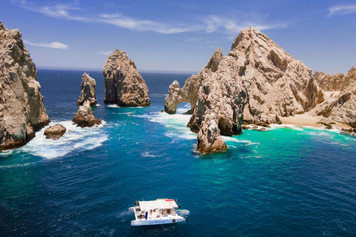 Aerial view of a catamaran cruising near the Arch rock formations