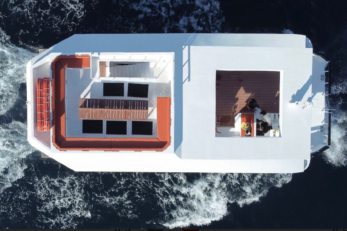 Aerial view of the open decks of a large event catamaran underway