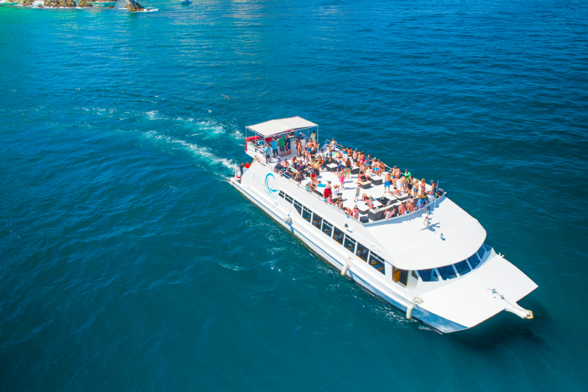 An event catamaran cruising with a large group on its open deck
